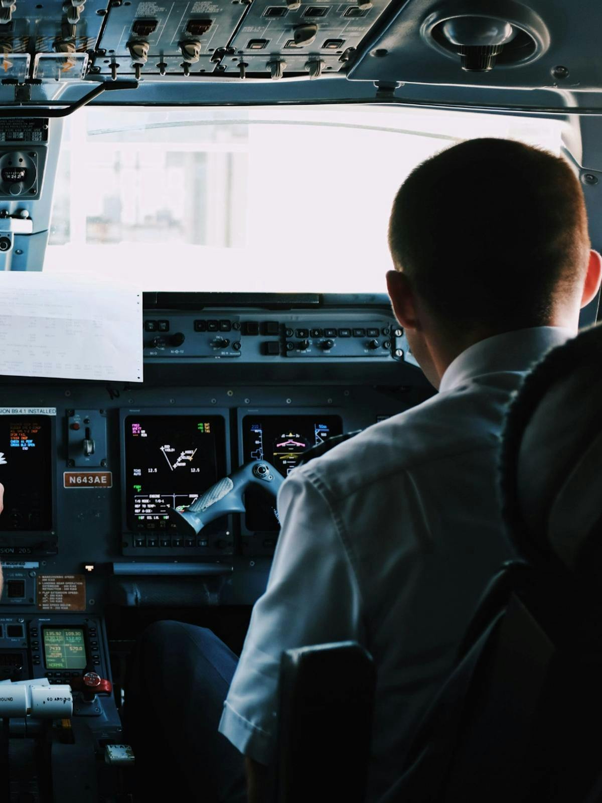 A pilot and a co-pilot inside the cockpit of a plane.